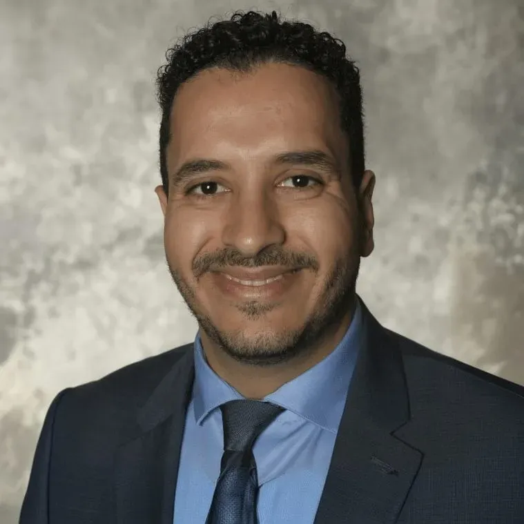 Dr. Beshoy Eskandar, dentist at Sahara Family Dental, smiling in a dark suit and tie.